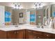 Bathroom with double sinks, granite countertop, framed mirrors and wood cabinets at 14607 Turning Leaf Ct, Tampa, FL 33626