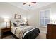 Cozy bedroom with neutral walls, ceiling fan, and window with plantation shutters at 14607 Turning Leaf Ct, Tampa, FL 33626