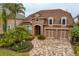 Aerial view of a home featuring three car garage, well-maintained lawn, and a brick paved driveway at 14607 Turning Leaf Ct, Tampa, FL 33626