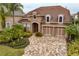 Aerial view of a home with a well-manicured lawn, tropical landscaping, and a brick-paved driveway at 14607 Turning Leaf Ct, Tampa, FL 33626