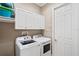 Laundry room with white cabinets, full-size washer and dryer, and coat hooks at 14607 Turning Leaf Ct, Tampa, FL 33626