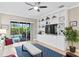 Inviting living room with built in shelving unit, ceiling fan, and sliding glass doors at 14607 Turning Leaf Ct, Tampa, FL 33626