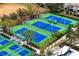 Aerial view of several blue and green tennis courts surrounded by trees and landscaping at 14607 Turning Leaf Ct, Tampa, FL 33626