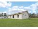 Wide shot of the home's backyard with new grass and back patio at 15422 Wine Dr, Weeki Wachee, FL 34614