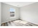 Bedroom with grey wood-look floors and a window providing natural light at 15422 Wine Dr, Weeki Wachee, FL 34614