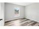 Bright bedroom featuring new grey-tone wood-look flooring and a window at 15422 Wine Dr, Weeki Wachee, FL 34614