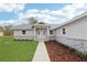 Close-up of the home's entry with attractive landscaping and a well-manicured lawn at 15422 Wine Dr, Weeki Wachee, FL 34614