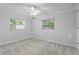 Spacious bedroom with two windows, carpet, and ceiling fan at 156 29Th N Ave, St Petersburg, FL 33704