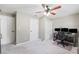 Carpeted bedroom with ceiling fan has two doors and closet perfect for a home office setup at 16908 Equestrian Trl, Odessa, FL 33556