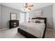 Bedroom features neutral carpeting, a queen bed, and a black dresser with decorative mirror at 16908 Equestrian Trl, Odessa, FL 33556