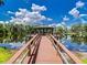 Scenic view of a gazebo with a wooden walkway over a serene lake reflecting the sky at 16908 Equestrian Trl, Odessa, FL 33556