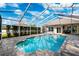 Inviting in-ground pool featuring a screened enclosure, stone patio, and a refreshing oasis at 16908 Equestrian Trl, Odessa, FL 33556