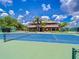 Well-maintained tennis court with community buildings and lush landscaping in the background at 16908 Equestrian Trl, Odessa, FL 33556