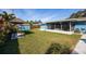 Expansive backyard with manicured lawn, cabana, storage shed, and screened lanai at 1745 Emerald Dr, Clearwater, FL 33756