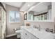 Bathroom with a granite vanity, tiled walls, modern fixtures, and an elegant mirror at 1745 Emerald Dr, Clearwater, FL 33756