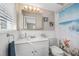 Bathroom with a sink, a white vanity, coastal themed decor, and a bright shower at 1745 Emerald Dr, Clearwater, FL 33756