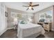 This bedroom features a ceiling fan, wood-look flooring, and plenty of natural light from the windows at 1745 Emerald Dr, Clearwater, FL 33756