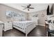 Cozy bedroom featuring a ceiling fan, wood-look flooring, and bright, natural light from the windows at 1745 Emerald Dr, Clearwater, FL 33756