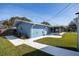 Well-maintained home exterior with a screened-in porch, pool area, and grassy backyard at 1745 Emerald Dr, Clearwater, FL 33756