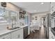 Bright kitchen featuring a stainless steel sink, white cabinets, and a cozy breakfast nook with wood-look flooring at 1745 Emerald Dr, Clearwater, FL 33756