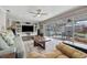 Comfortable living room featuring a large TV, built-in shelving, and a sliding glass door leading to the patio at 1745 Emerald Dr, Clearwater, FL 33756