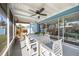 Relaxing screened patio with tile floor, ceiling fan, white furniture, and view of the backyard at 1745 Emerald Dr, Clearwater, FL 33756