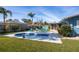 Backyard features a kidney-shaped pool, blue Adirondack chairs, palm trees, shed, and well-maintained landscaping at 1745 Emerald Dr, Clearwater, FL 33756