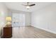 Bright bedroom featuring ceiling fan, wood flooring, and sliding glass door for patio access at 1901 Andover Way # 32, Sun City Center, FL 33573