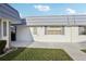 Bright exterior of a well-maintained condo featuring a white exterior, grey roof, and manicured lawn at 1901 Andover Way # 32, Sun City Center, FL 33573