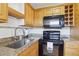 Close-up of the kitchen area showcasing stainless steel sink, granite countertops, and tile backsplash at 1901 Andover Way # 32, Sun City Center, FL 33573