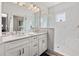 Bright bathroom featuring glass-enclosed shower, and white cabinets with double sinks at 192 Haven Beach Dr, Indian Rocks Beach, FL 33785