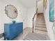 Bright foyer with staircase, tiled floor, and decorative chest under a mirror exudes elegance at 192 Haven Beach Dr, Indian Rocks Beach, FL 33785