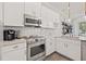 Modern kitchen featuring stainless steel appliances, granite countertops and white cabinets at 192 Haven Beach Dr, Indian Rocks Beach, FL 33785