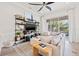 Comfortable living room with stylish shelving, ceiling fan, and sliding glass doors to screened lanai at 192 Haven Beach Dr, Indian Rocks Beach, FL 33785