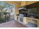 Outdoor kitchen complete with a grill, granite counters, sink, and storage, perfect for entertaining at 192 Haven Beach Dr, Indian Rocks Beach, FL 33785