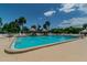 Community pool area with palm trees and tiki huts for relaxation at 205 S Mcmullen Booth Rd # 202, Clearwater, FL 33759