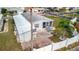 Aerial view of home with an adjacent carport, small patio, palm tree and white fence at 206 S Port Royal Ln, Apollo Beach, FL 33572