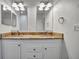 Well-lit bathroom featuring a dual sink vanity with granite countertops and ample lighting, creating a luxurious and practical space at 206 S Port Royal Ln, Apollo Beach, FL 33572