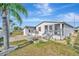 Charming home featuring a screened porch, updated siding, and a well-maintained lawn with mature landscaping at 206 S Port Royal Ln, Apollo Beach, FL 33572