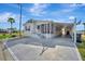 Single-story home with covered parking and landscaped yard surrounded by palm trees at 206 S Port Royal Ln, Apollo Beach, FL 33572