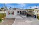 Single-story home featuring a screened porch, carport, brick-paver driveway and light gray exterior at 206 S Port Royal Ln, Apollo Beach, FL 33572