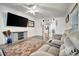 Inviting living room with a large-screen TV, ceiling fan, and wood-look floors, creating a cozy space at 206 S Port Royal Ln, Apollo Beach, FL 33572