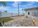 Back patio with block pavers, vinyl fencing, an exterior door, and view of palm trees at 206 S Port Royal Ln, Apollo Beach, FL 33572