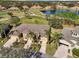 Aerial view featuring the property, landscaping, a nearby lake, and golf course in a community at 2471 Kensington Greens Dr, Sun City Center, FL 33573