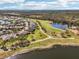 Community aerial view showcasing the golf course, ponds, lush greenery, and well-spaced homes at 2471 Kensington Greens Dr, Sun City Center, FL 33573