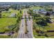 Beautiful aerial shot showing a community entrance with manicured landscaping, lush lawns, and a tranquil pond at 2471 Kensington Greens Dr, Sun City Center, FL 33573