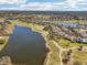 Gorgeous aerial view showcasing a community with lake, golf course, lush green landscaping, and a variety of houses at 2471 Kensington Greens Dr, Sun City Center, FL 33573