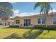 Exterior backyard view highlighting well-kept lawn, sparse landscaping, and outdoor patio chairs at 2471 Kensington Greens Dr, Sun City Center, FL 33573