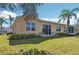 Home exterior with a well-manicured lawn, simple landscaping, and outdoor seating area at 2471 Kensington Greens Dr, Sun City Center, FL 33573