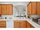 A well-lit kitchen with a white countertop and oak cabinets, offering open view to the living area at 2471 Kensington Greens Dr, Sun City Center, FL 33573